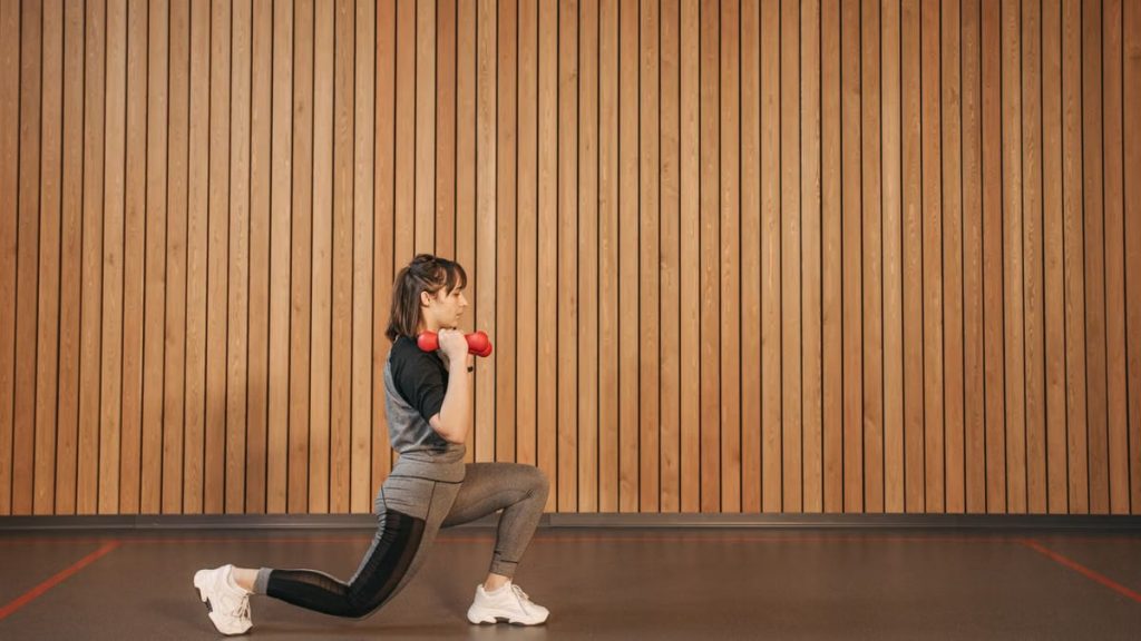 Side view of a woman exercising with dumbbells, promoting fitness and a healthy lifestyle.